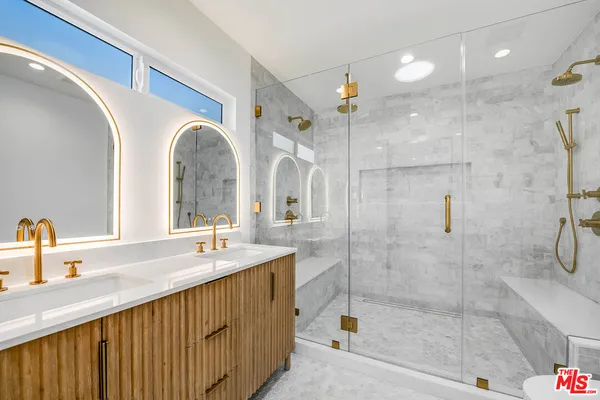a bathroom with a double vanity sink mirror and shower