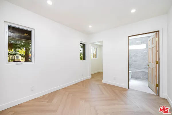 an empty room with windows and closet