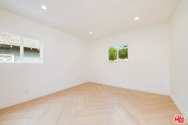 a front view of a house with a yard and potted plants