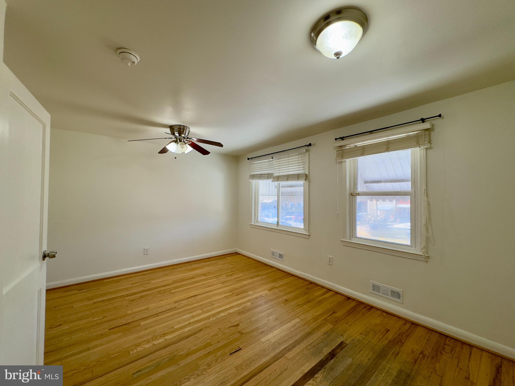 512 Umbra Street Baltimore, MD 21224 - Photo 11 of 20 a view of an empty room with a window and wooden floor