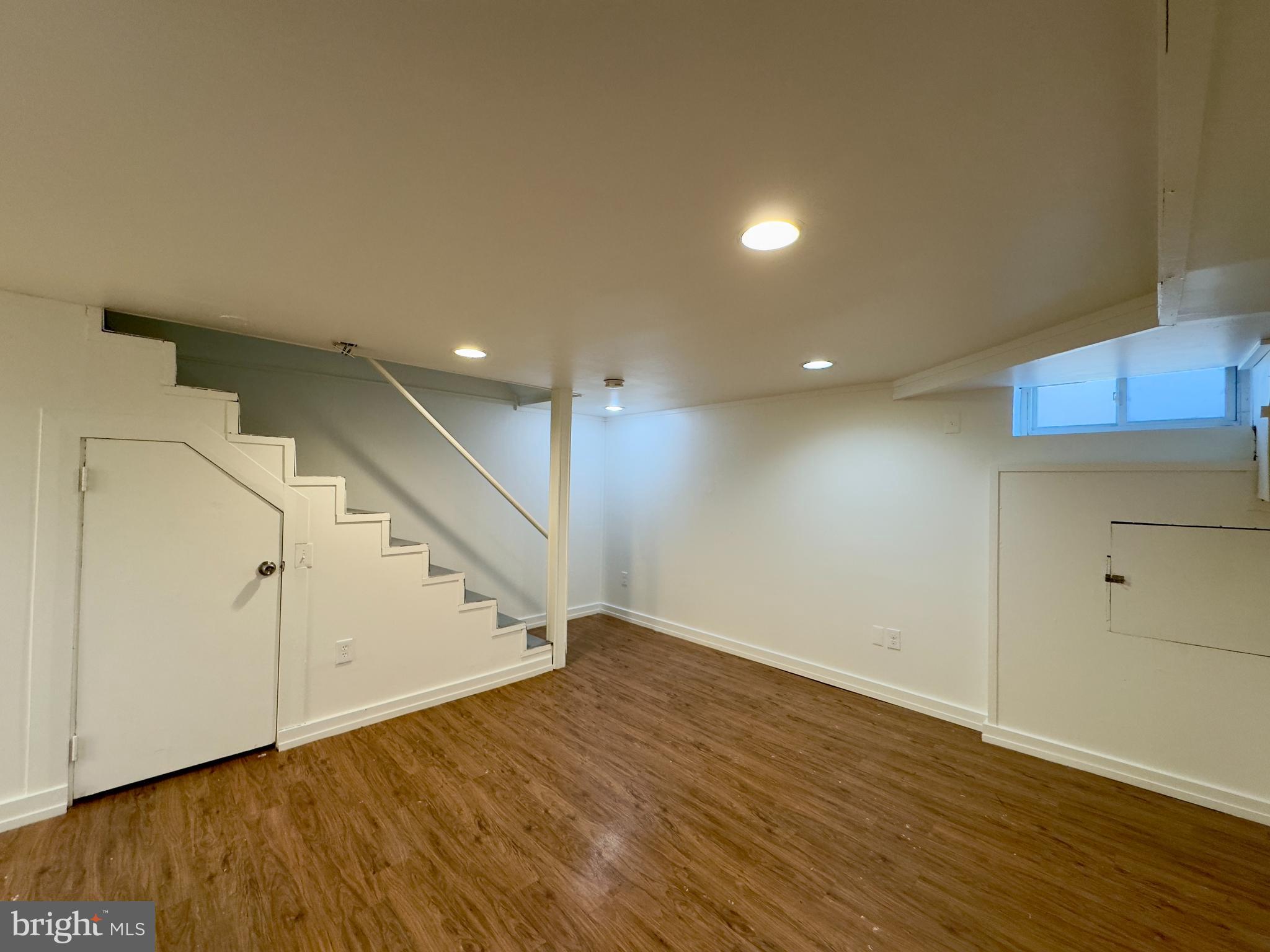 512 Umbra Street Baltimore, MD 21224 - Photo 15 of 20 an empty room with wooden floor and staircase