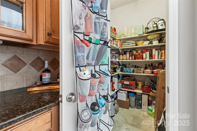 a kitchen with stainless steel appliances granite countertop a stove a sink dishwasher a refrigerator with a dining table and chairs