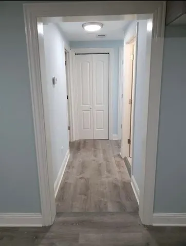a view of a hallway with wooden floor