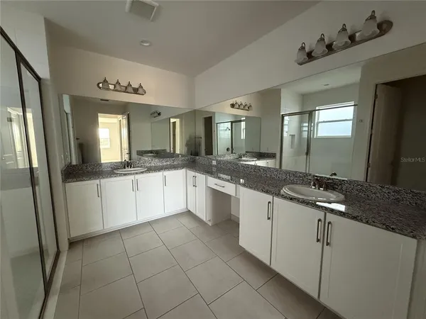 a large white kitchen with a sink and dishwasher a refrigerator with white cabinets