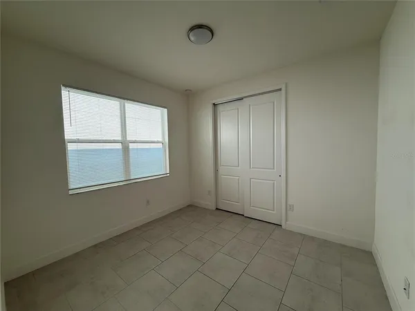 an empty room with windows and closet