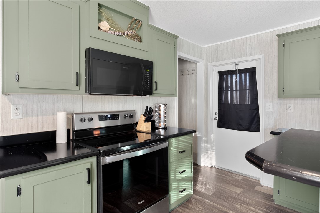 862 North Old Mill Road Easley, SC 29640 - Photo 6 of 24 This kitchen features a microwave and electric range, with light green cabinets and dark countertops.