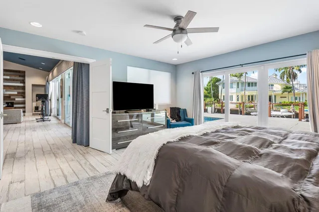 a spacious bedroom with a bed and a flat screen tv