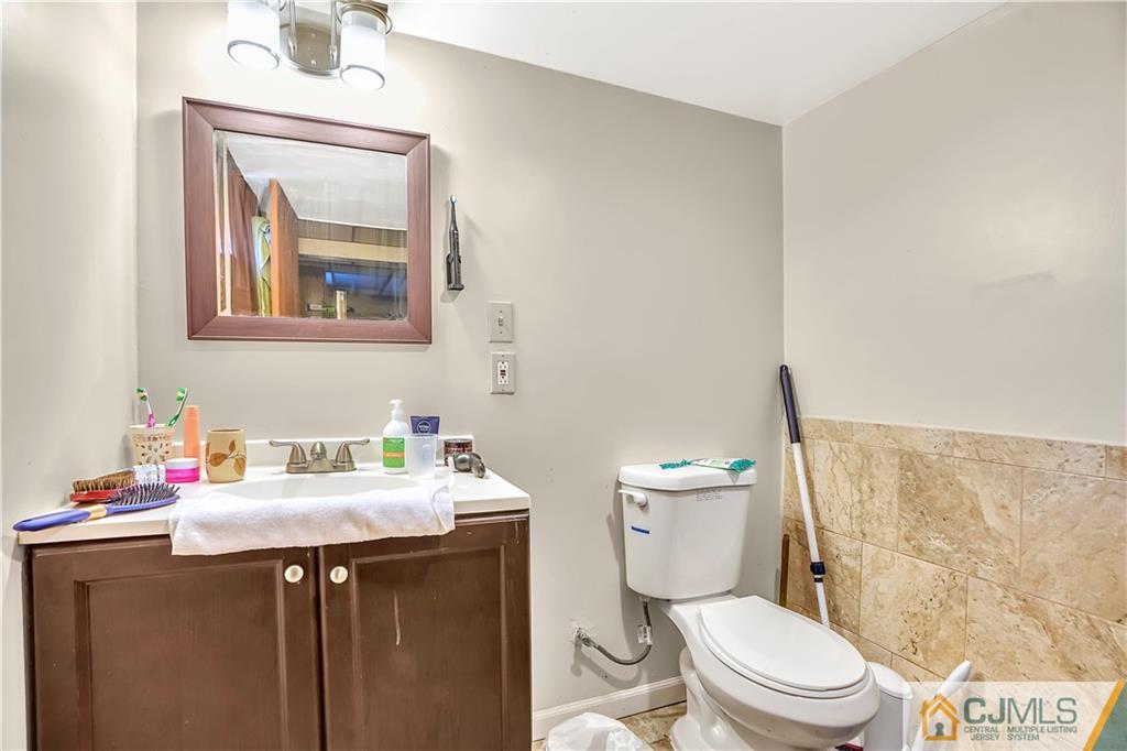 141 Old Road Sewaren, NJ 07077 - Photo 20 of 30 a bathroom with a toilet sink vanity and mirror