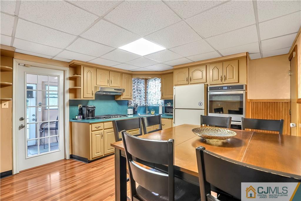 141 Old Road Sewaren, NJ 07077 - Photo 7 of 30 a kitchen with a table chairs refrigerator and cabinets