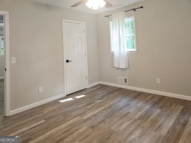 an empty room with wooden floor and closet area