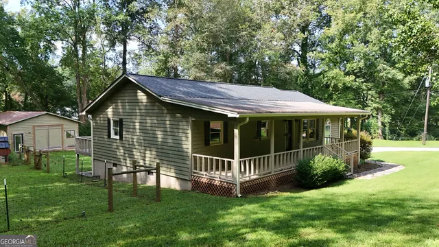 a view of a house with a yard and sitting area