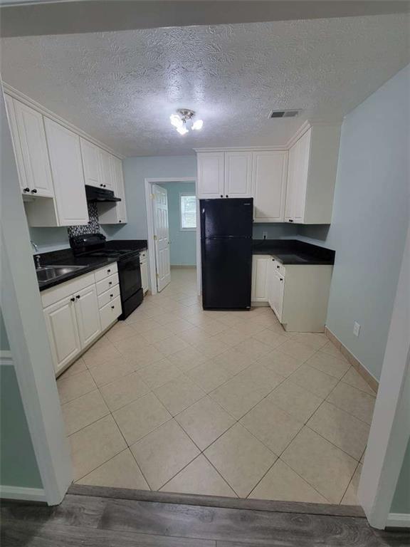 4648 Pine Tree Circle, Unit B Buford, GA 30518 - Photo 12 of 19 a large white kitchen with a refrigerator a stove a microwave and cabinets