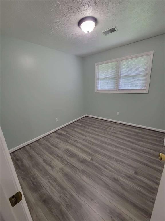 4648 Pine Tree Circle, Unit B Buford, GA 30518 - Photo 16 of 19 an empty room with wooden floor and windows