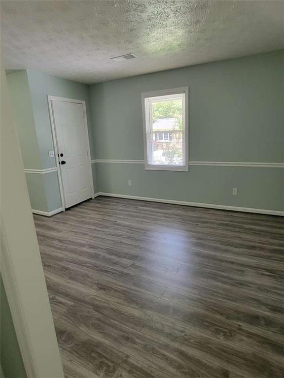 4648 Pine Tree Circle, Unit B Buford, GA 30518 - Photo 4 of 19 an empty room with wooden floor and windows