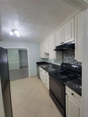 a kitchen with granite countertop a stove and a refrigerator
