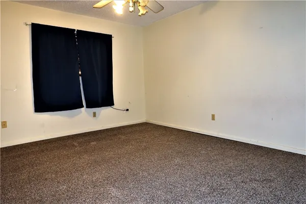 an empty room with wooden floor and cabinet