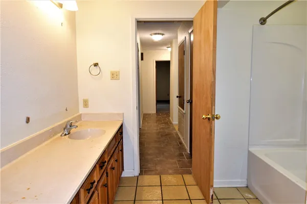 a bathroom with a tub sink and shower