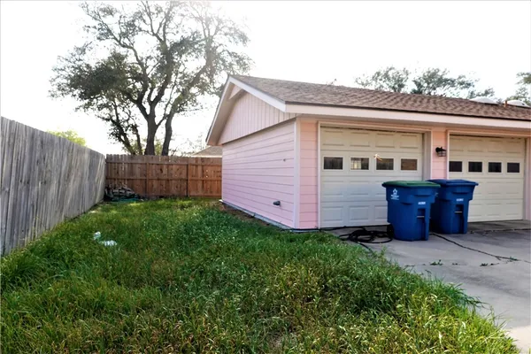 a view of backyard with barbeque grill and wooden fence