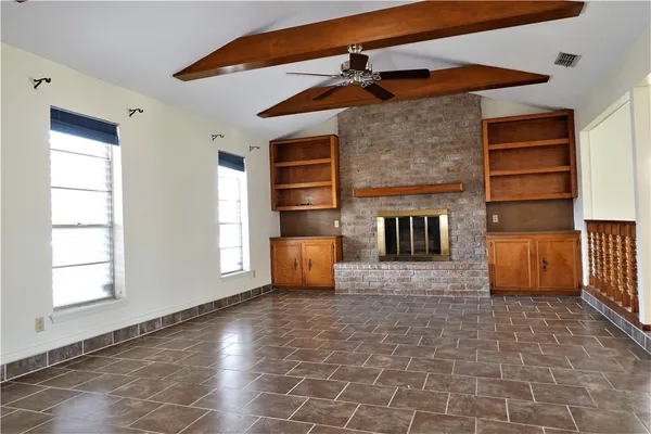 a view of a livingroom with a fireplace and a window
