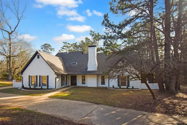 a front view of a house with yard and trees