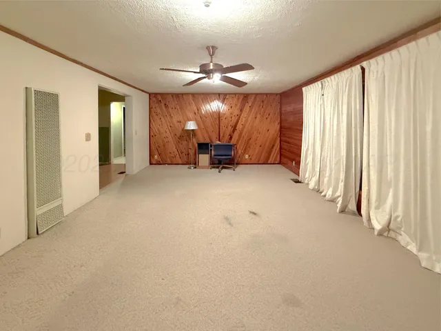 an empty room with fireplace and windows