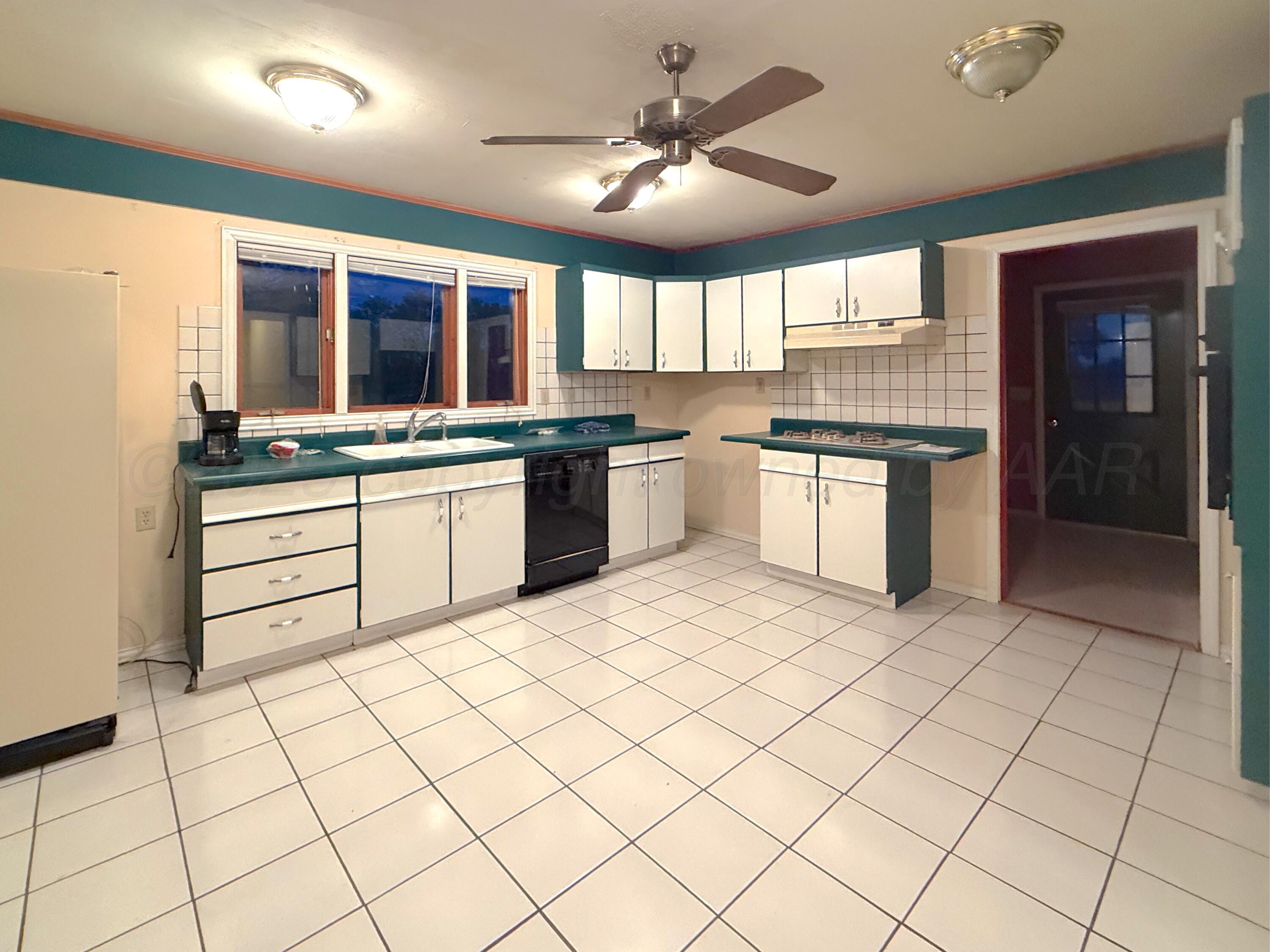 301 West 10th Street Stinnett, TX 79083 - Photo 5 of 15 a kitchen with stainless steel appliances granite countertop a sink and cabinets