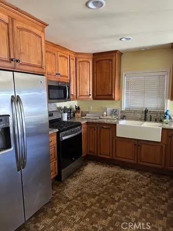 a kitchen with stainless steel appliances granite countertop a stove a sink and a refrigerator