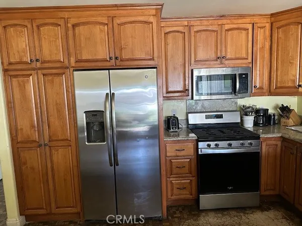 a kitchen with stainless steel appliances granite countertop a refrigerator stove and sink