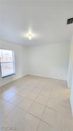 an empty room with windows and brick wall