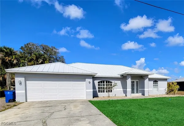 a front view of a house with a garden and yard