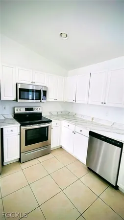 a kitchen with granite countertop white cabinets and stainless steel appliances