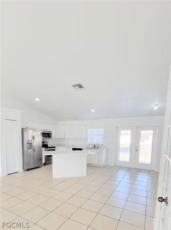 a large white kitchen with cabinets and a refrigerator
