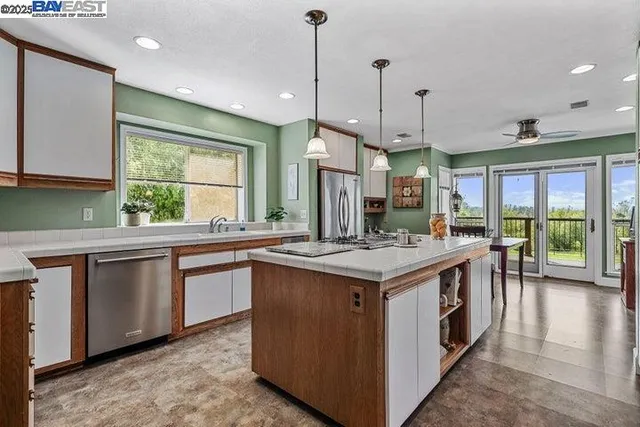 a kitchen with kitchen island a sink stove and refrigerator