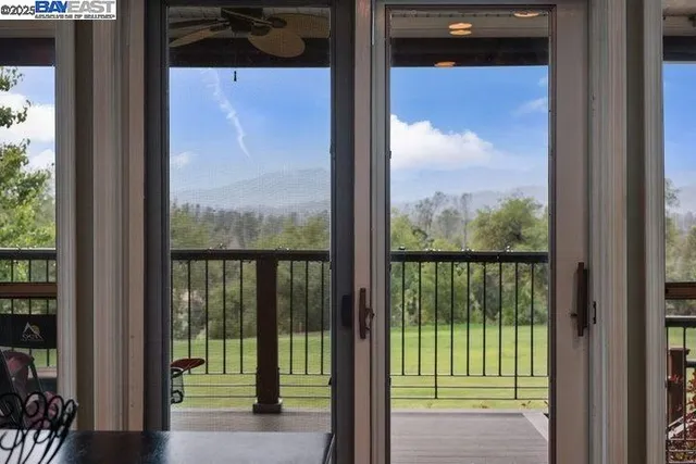 a view of patio with table and chairs potted plants with floor to ceiling window