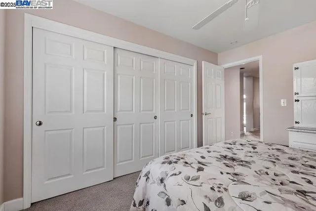 a bedroom with a bed couch and large window