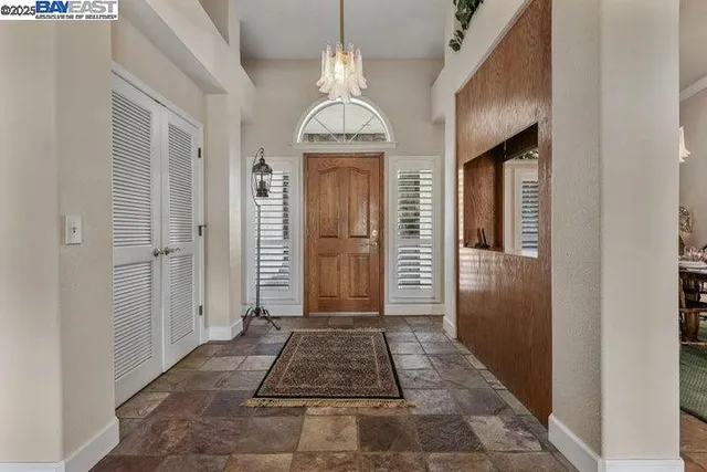 a view of a hallway view with wooden floor and a living room