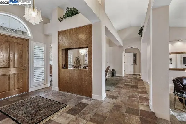 a view of a dining room with furniture a chandelier and wooden floor