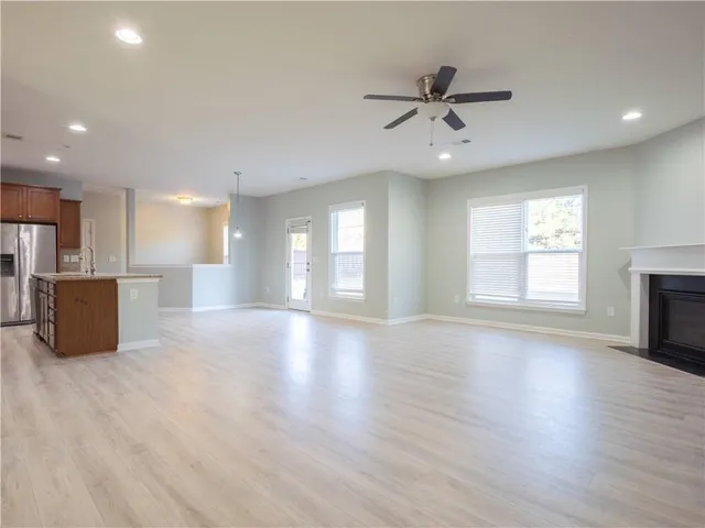 a view of an empty room with window and wooden floor