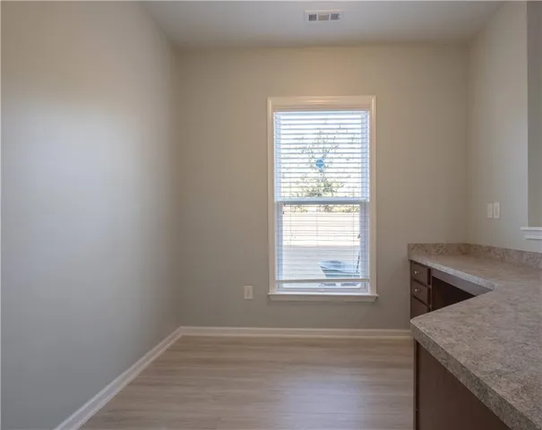 an empty room with wooden floor and window