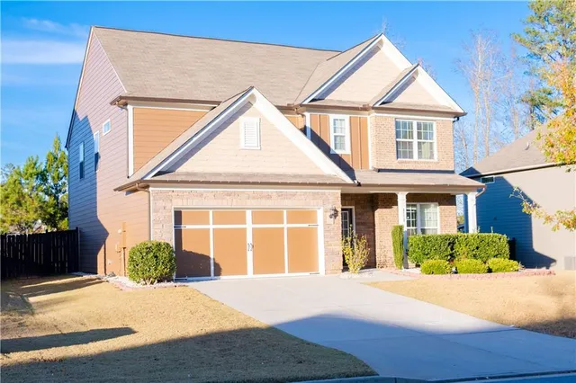 a front view of a house with a yard and potted plants