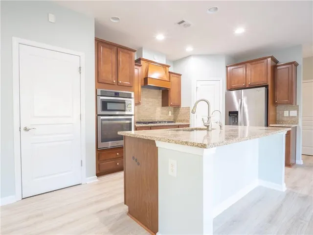 a kitchen with stainless steel appliances granite countertop a refrigerator and a sink