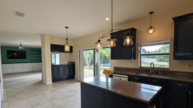 a kitchen with kitchen island a sink appliances and a counter top space