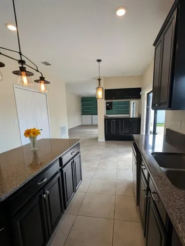 a kitchen with stainless steel appliances granite countertop a sink a stove and a wooden cabinets