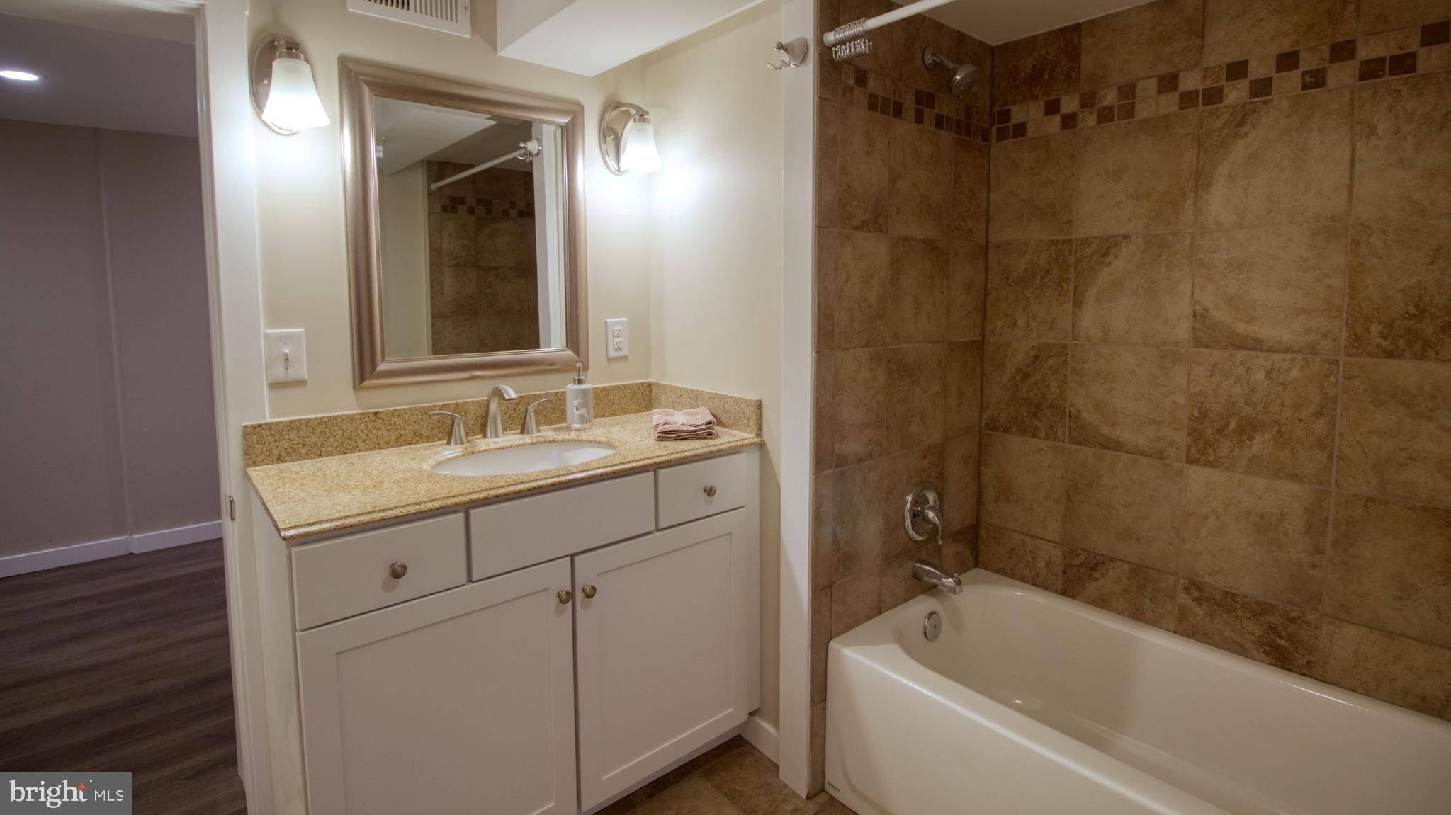 222 State Street Enola, PA 17025 - Photo 37 of 42 a bathroom with a sink a mirror a bathtub and shower