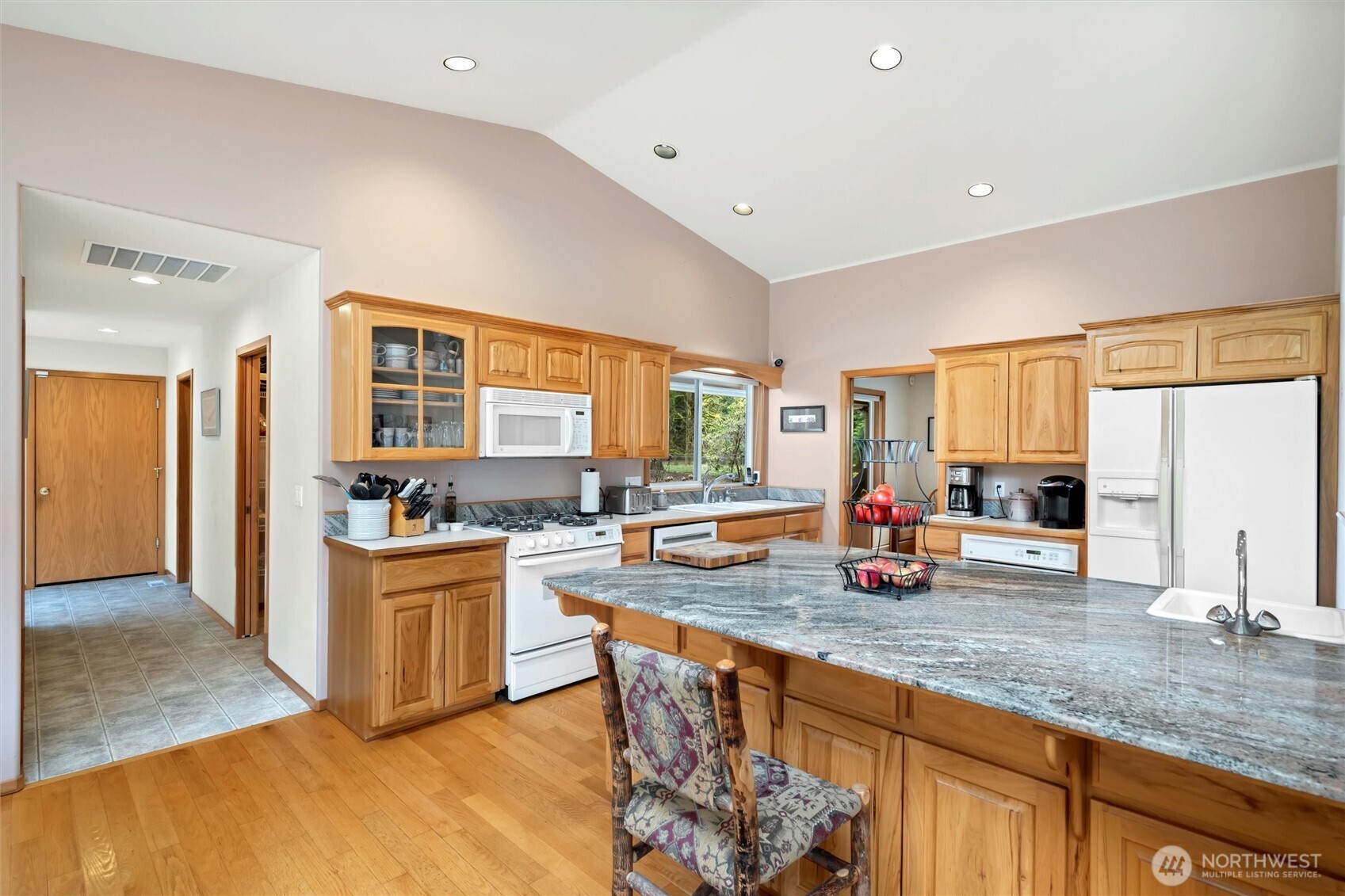 6170 Rutsatz Road Deming, WA 98244 - Photo 10 of 40 a kitchen with stainless steel appliances granite countertop a stove top oven a sink dishwasher a dining table and chairs with wooden floor