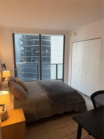 a bedroom with a bed and glass door