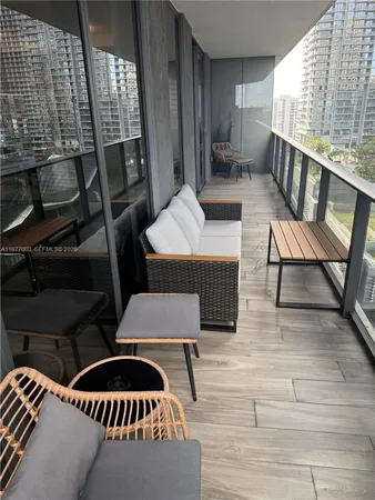 a view of a living room with a floor to ceiling window and wooden floor