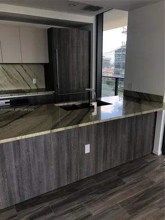 a view of kitchen with wooden floor and cabinets