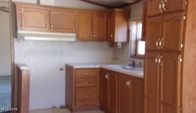 2270 Tatmans Road Southeast Corning, OH 43730 - Photo 5 of 14 Kitchen with brown cabinetry, light countertops, and a sink