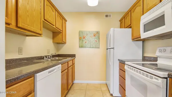 a kitchen with a sink a refrigerator and cabinets
